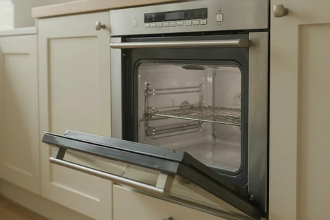 Open stainless steel oven with a clean interior and glass door